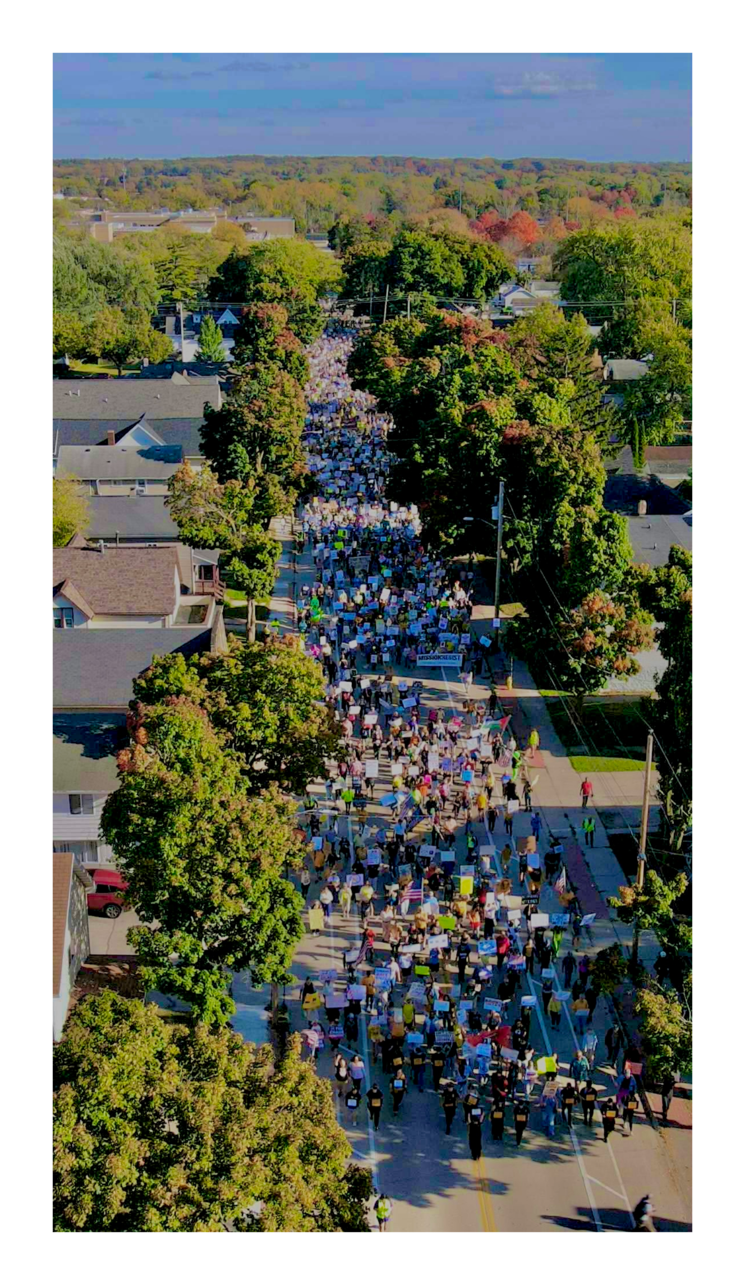 aerial view of several hundred people marching in the street